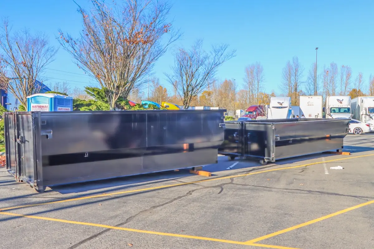 Professional dumpster rental service with roll-off container on residential driveway in North East